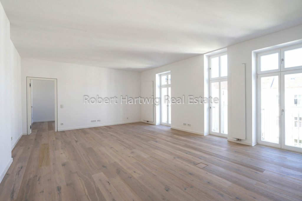 Heller Wohnbereich mit drei Fenstern und Parkett